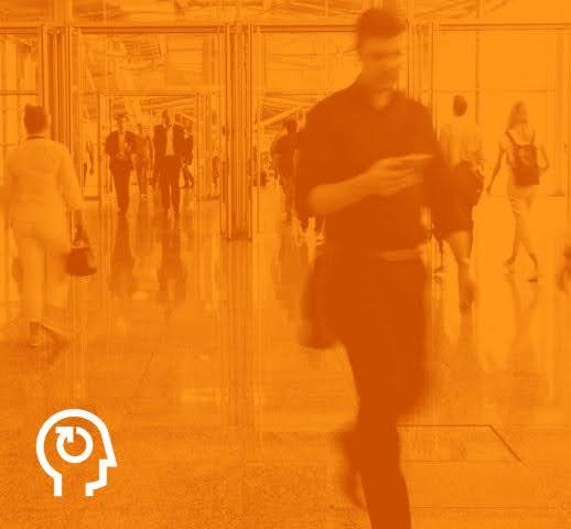 Busy indoor office building with a man walking on his own, standing out as a new leader, with a faded orange overlay and the Basadur icon in the corner.