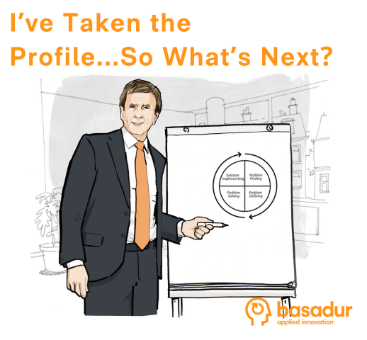 Caricature of Dr. Min Basadur of Basadur Applied Innovation, wearing a black suit and orange tie, standing beside a flip chart and pointing to a circular drawing of the 4 stages of the creative problem solving process.